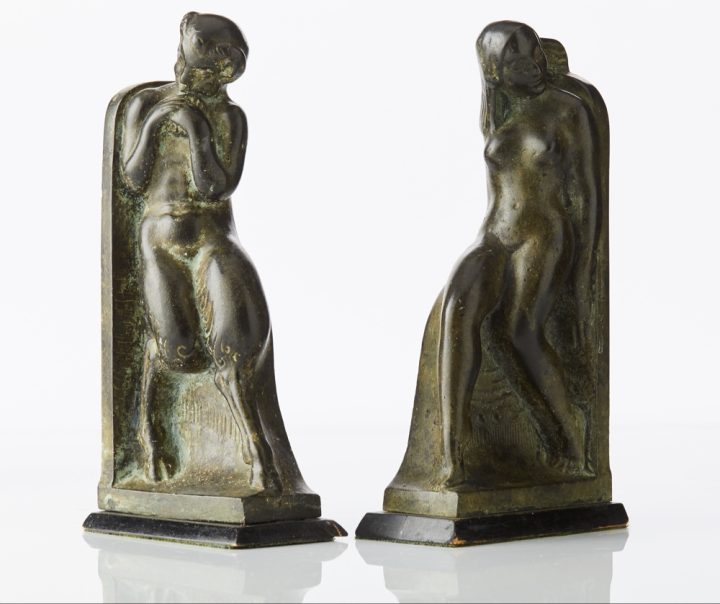 Bokstöd, ett par av Axel Gute i patinerad brons på träsockel föreställande Pan och Syrinx, 1909